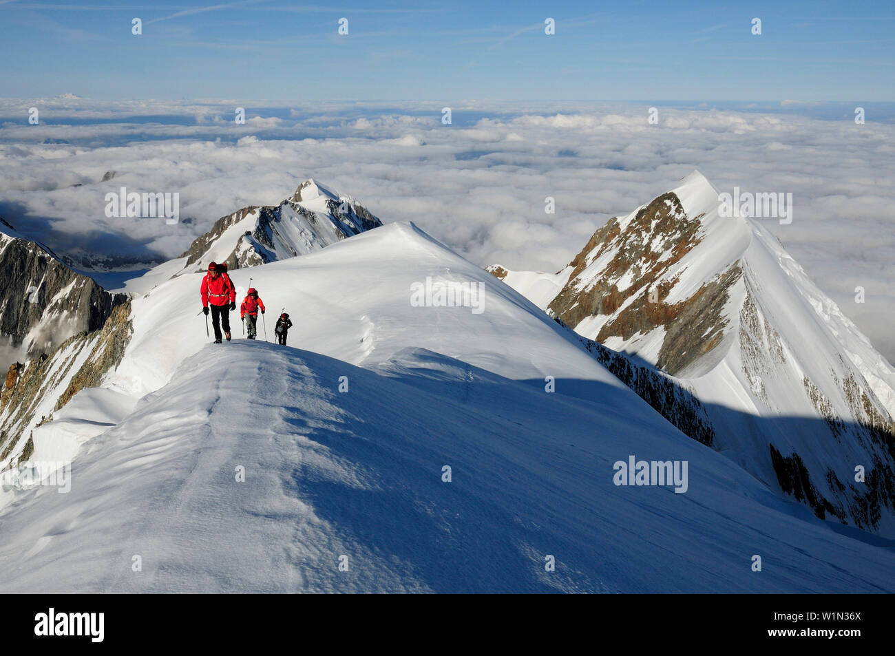 Bergsteiger beim Aufstieg auf den Dome de Gouter, Aiguille de Bionnassay im Hintergrund, Mont Blanc, Frankreich Stockfoto