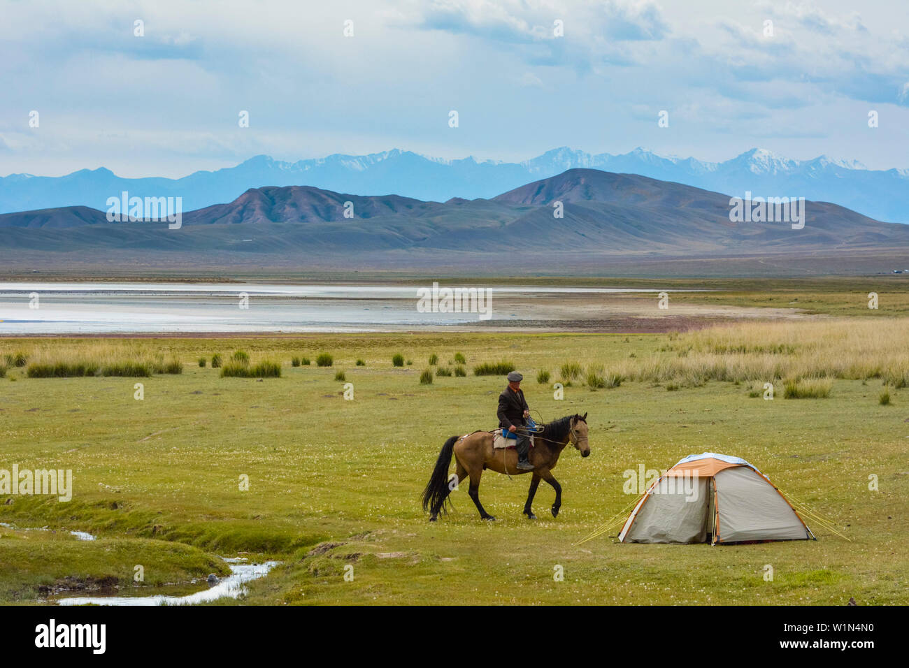 Alter Mann auf einem Pferd reiten zu einem Zelt in der Steppe, Tuzkoel Salt Lake, Tuzkol, Tien Shan, Tian Shan, Almaty, Kasachstan, Zentralasien, Asien Stockfoto