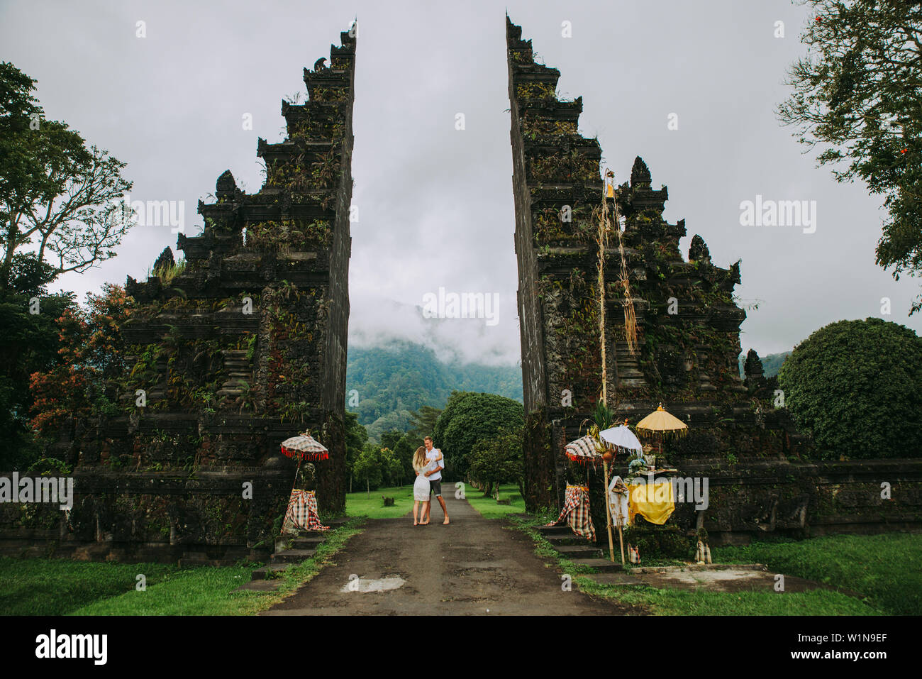 Glückliches Paar Ausgabe Zeit an Der handara Tor in Bali. zu Fuß auf der Straße zum historischen Tür Stockfoto