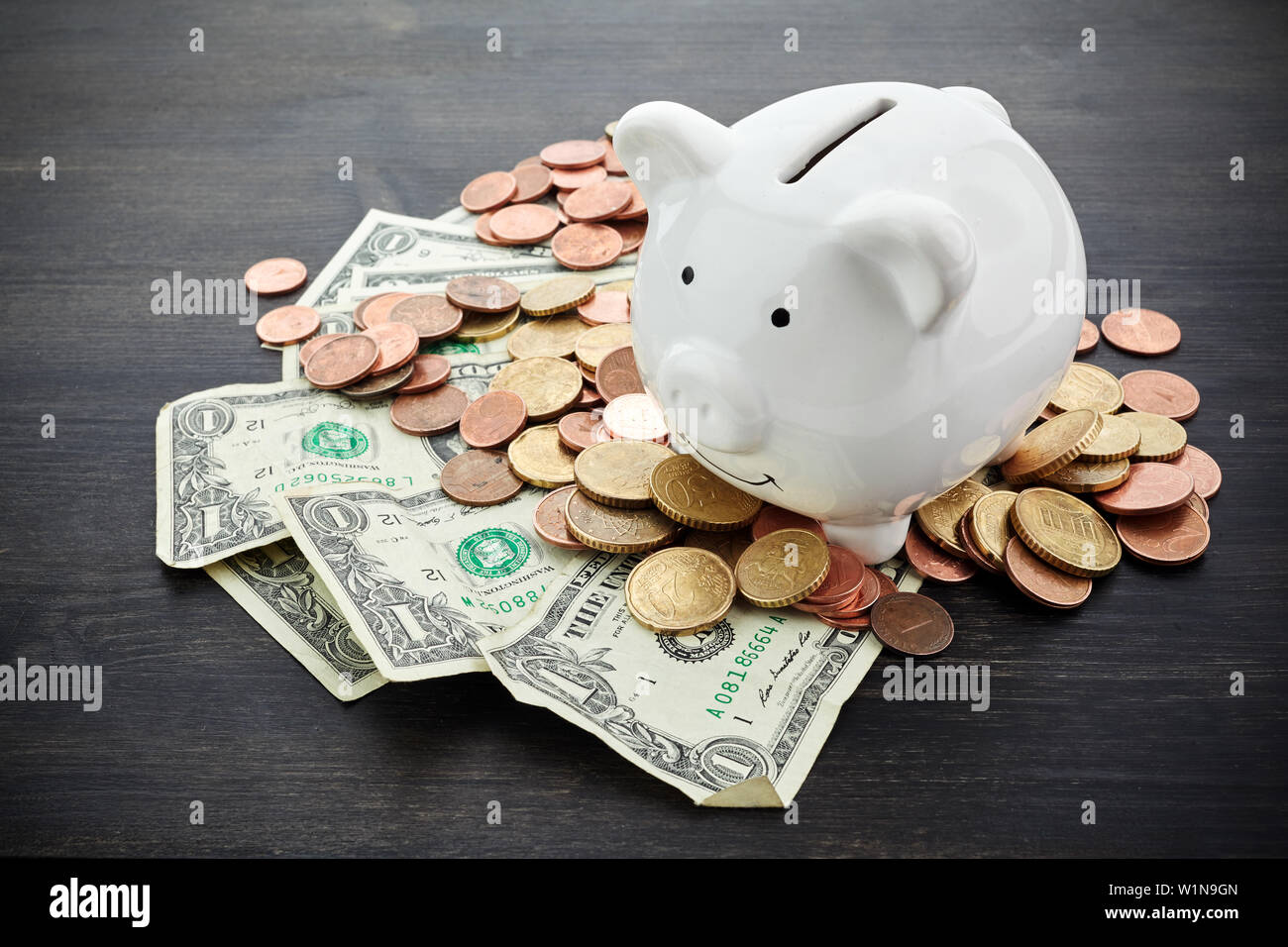 Piggy Bank mit Geld auf schwarze hölzerne Hintergrund Stockfoto