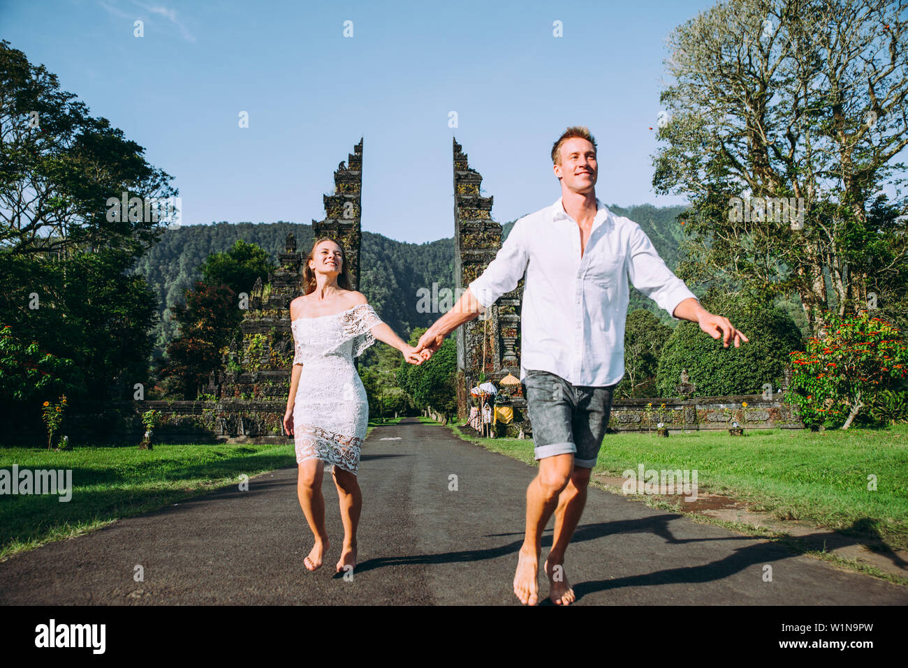 Glückliches Paar Ausgabe Zeit an Der handara Tor in Bali. zu Fuß auf der Straße zum historischen Tür Stockfoto