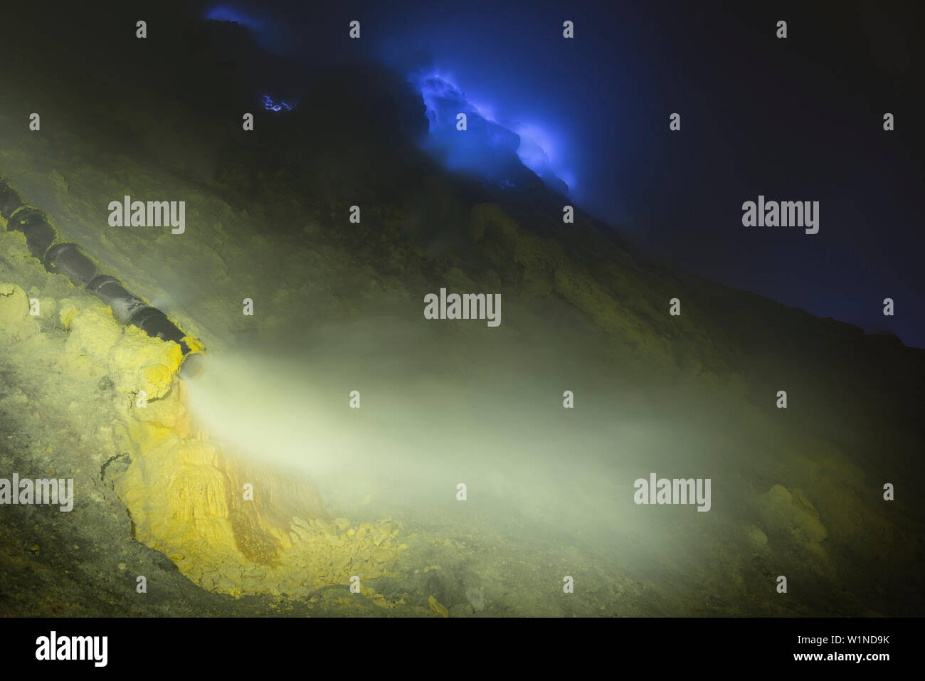 Schwefel und blaue Flammen des Vulkans Ijen in der Nacht. Die Übertragung von heißen schwefelhaltigen Gasen für Abkühlung. Schwefel Hinterlegung in fester Form, Eas Stockfoto