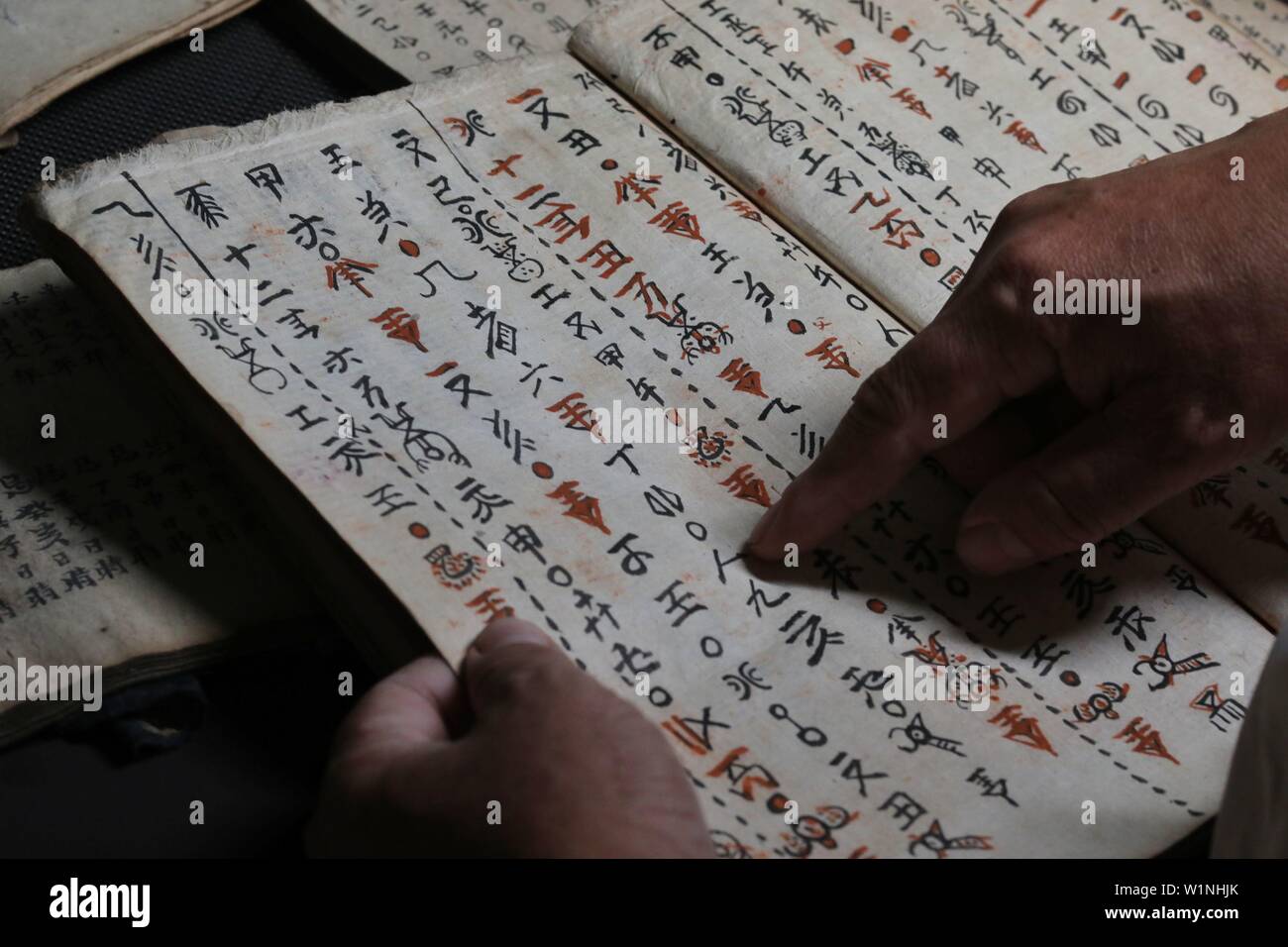 (190703) - SANDU, Juli 3, 2019 (Xinhua) - kulturwissenschaftler Wei Shizhao organisiert eine Sammlung von Texten in Shui Skript in Sandu County, im Südwesten Chinas Provinz Guizhou, 3. Juli 2019. Wei begann Shui Skript in seiner Kindheit. So weit, seine moderne chinesische Übersetzungen von Texten in Shui Skript haben, fast drei Millionen Zeichen betragen. Die Shui Skript ist der einzigartige Piktografische schreiben System durch die Shui Menschen im Südwesten Chinas verwendet, Aufzeichnungen über ihre Kultur halten. Invente wie die Bronze- und Oracle Knochen Inschriften des alten China, die Shui Skript besteht aus logograms Stockfoto