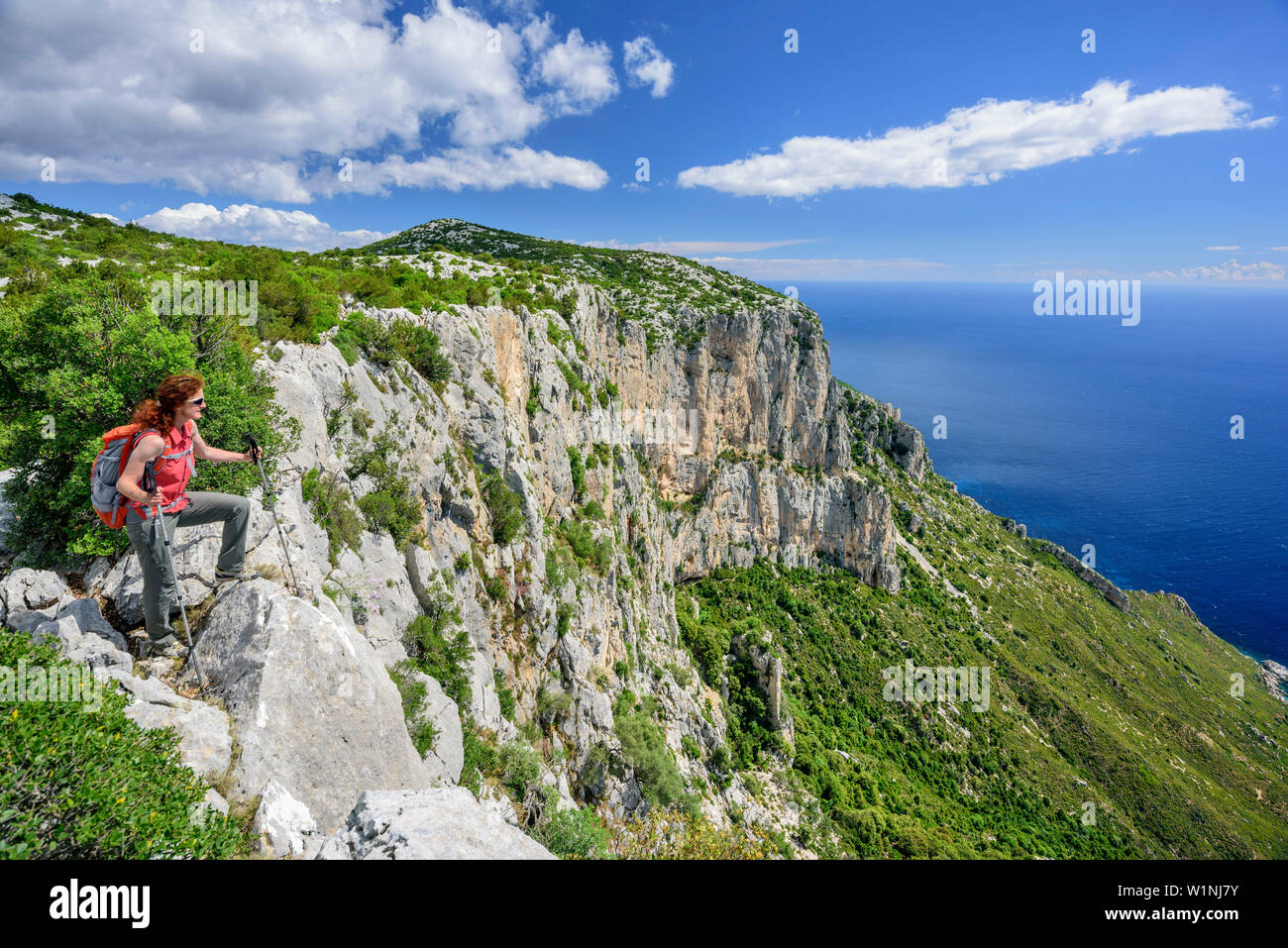 Frau wandern Selvaggio Blu stehend an Cliff und Blick auf Küste des Golfo di Orosei, Selvaggio Blu, National Park in der Bucht von Orosei und Gennargent Stockfoto