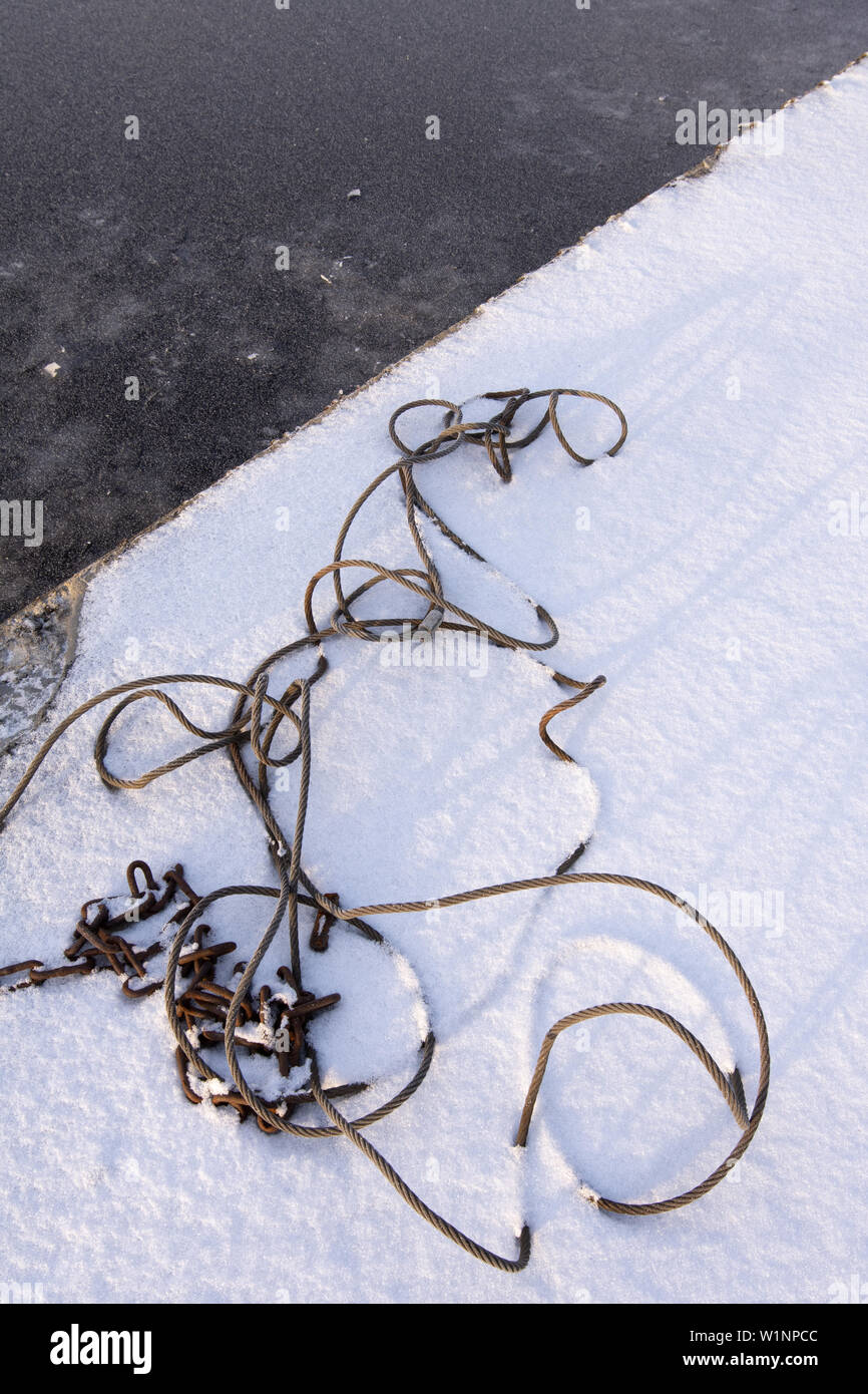 Stahldrahtseil Kabel und rostige Kette im Schnee Stockfoto