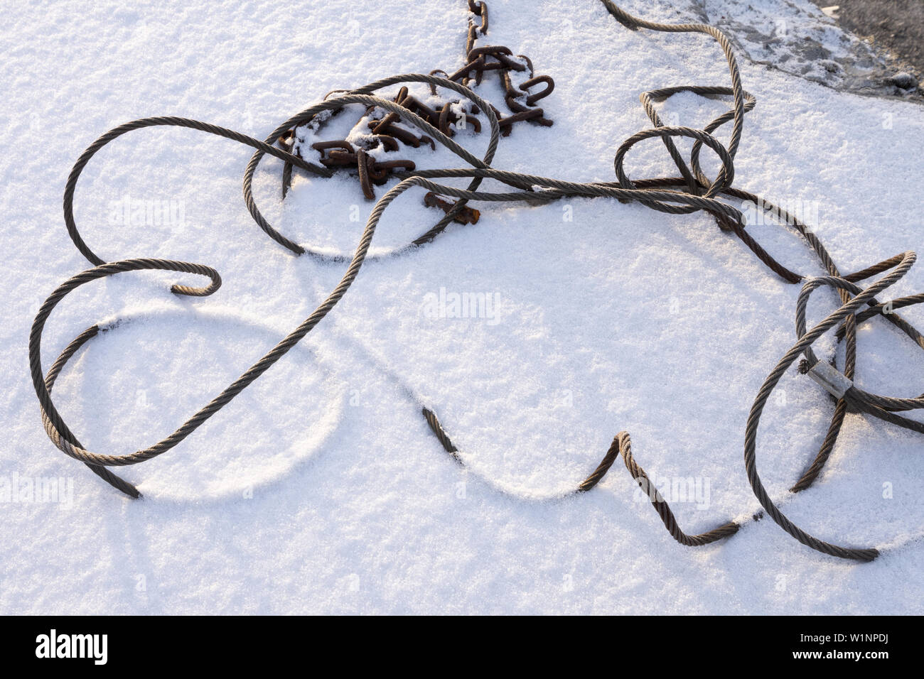 Stahldrahtseil Kabel und rostige Kette im Schnee Stockfoto