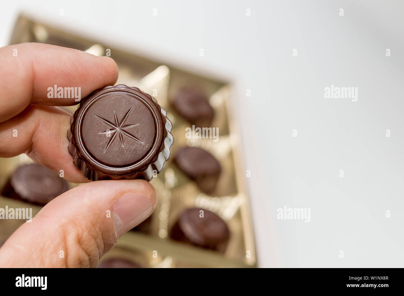 Einen Mann mit einer Schokolade aus einer Schachtel Pralinen. Stockfoto