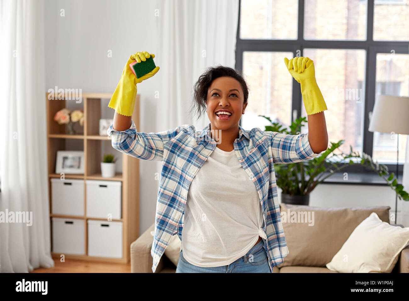 Gerne afrikanische Frau mit Schwamm Reinigung zu Hause Stockfoto