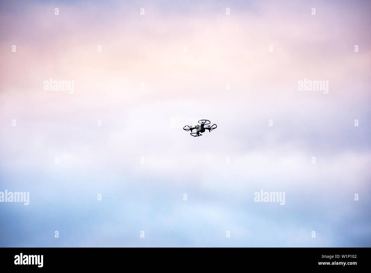 Schwarz Drohnen fliegen in den Himmel mit vielen Cloud und Morgenlicht. Stockfoto