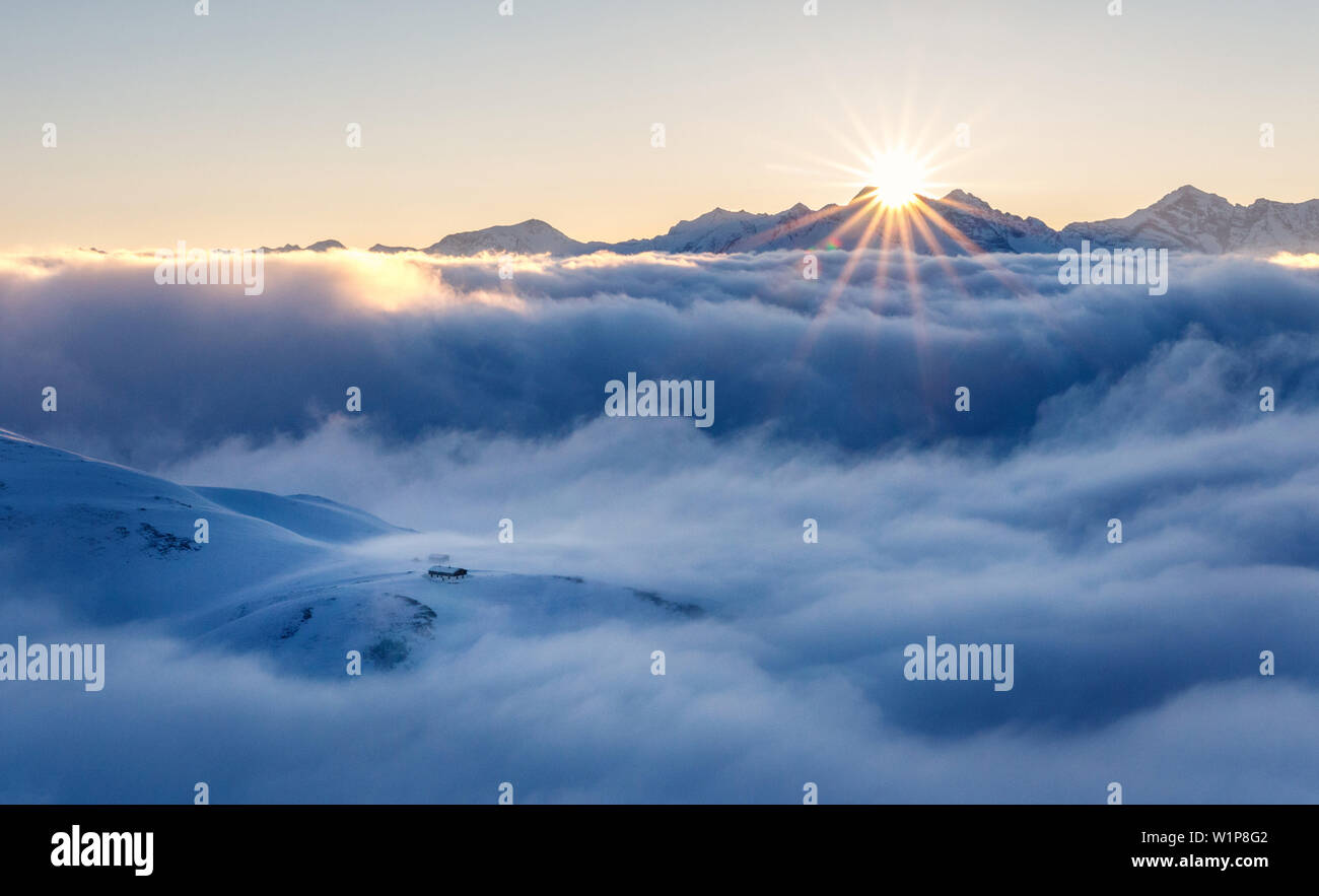 Sonnenaufgang über einem Meer der Wolken, die Hütte ist mit Blick auf die Wolken, Brenner Berge, Stubaier Alpen, Tirol, Österreich Stockfoto