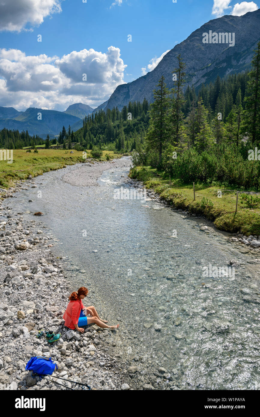 Der Lechweg wandern Frau badet, die Füße im Lech Lech Quelle Berge, Vorarlberg, Österreich Stockfoto