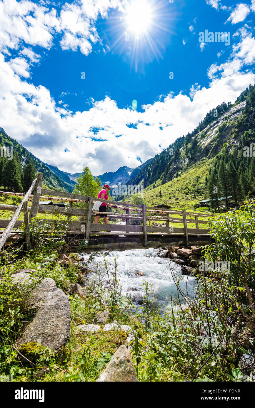 Ein Wanderer die Brücke mit einem Bergbach am Anfang der hohe Tal auf dem Weg in die Maxhütte, Ginzling, Zillertal, Tirol, Österreich Stockfoto