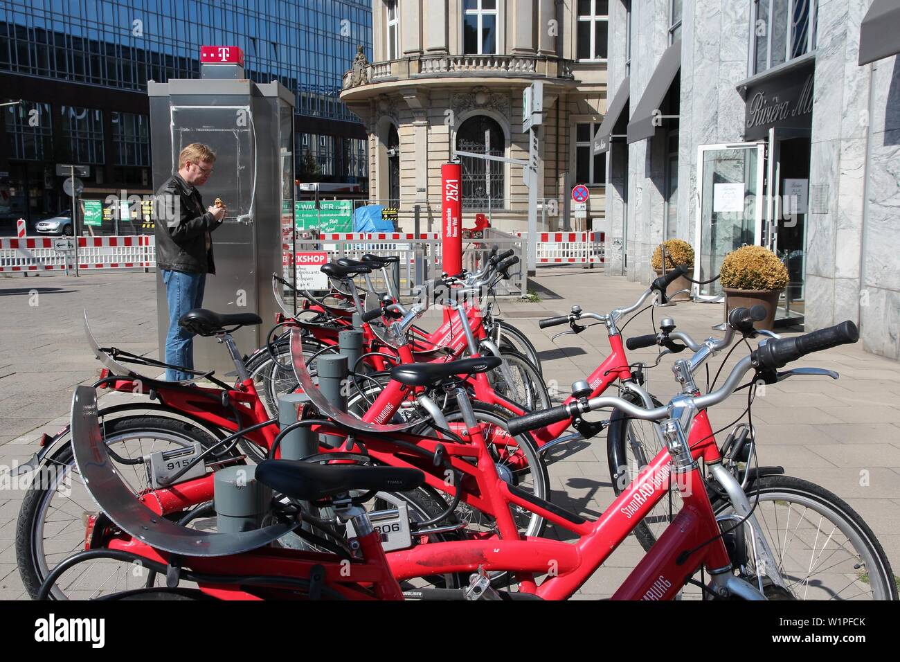 HAMBURG, DEUTSCHLAND - 28. AUGUST 2014: Person Wanderungen mit dem Fahrrad die Sharing Station von stadtrad Hamburg. Stadtrad hat 72 Stationen und einer Flotte von 1.000 bicy Stockfoto