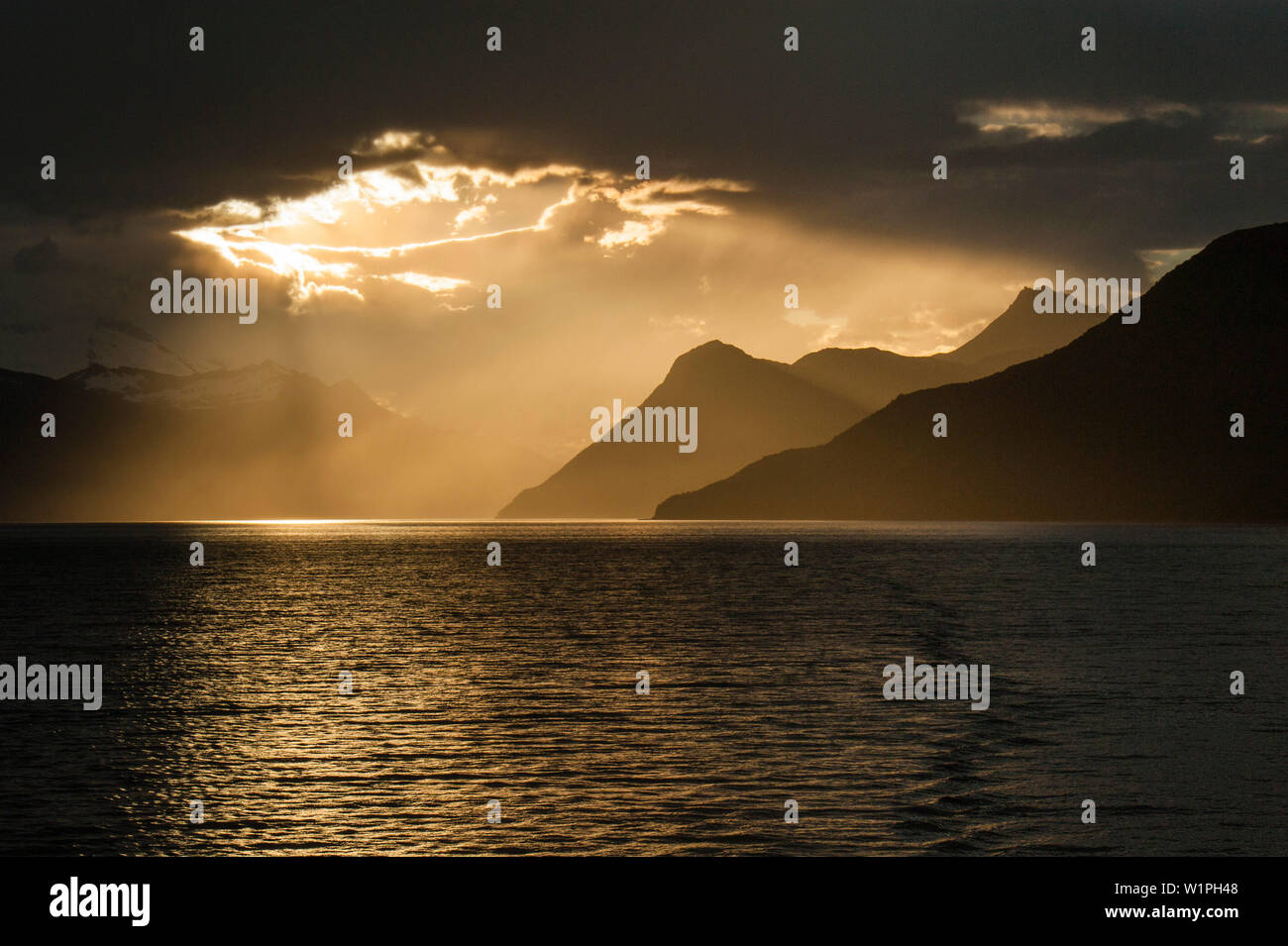 Sonne bricht durch Cloud-Abdeckung von der chilenischen Küste, Beagle Kanal, Alberto De Agostini Nationalpark, Magallanes y de la Antarktis Chilena, Patagonien Stockfoto