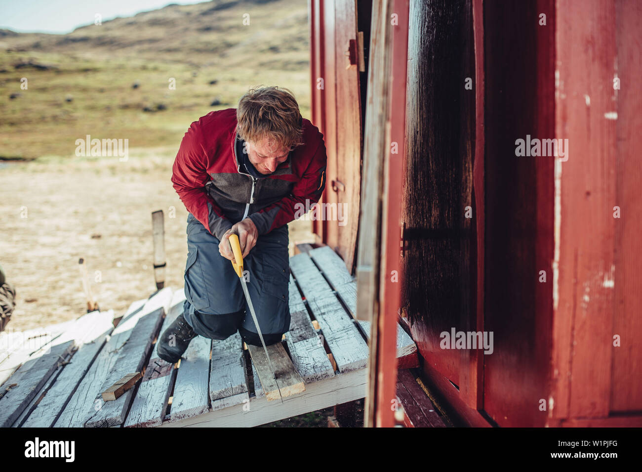 Man Schneiden von Holz, Grönland, Arktis. Stockfoto
