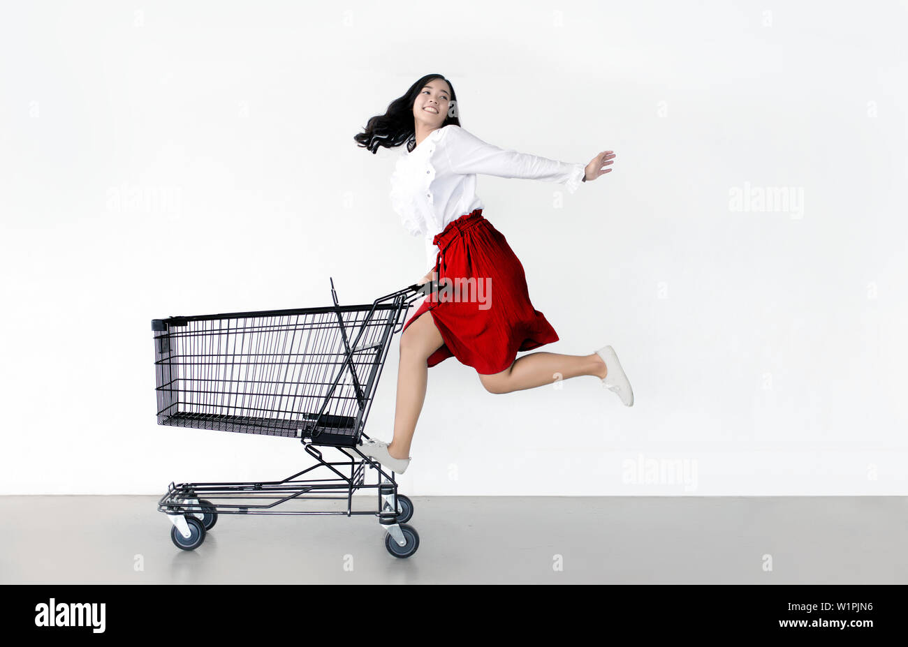 Gerne asiatische Frau mit Warenkorb für den Einkauf auf Verkauf Jahreszeit bereit - Schöne lässigen shopper Mädchen gehen zu den Store. Stockfoto