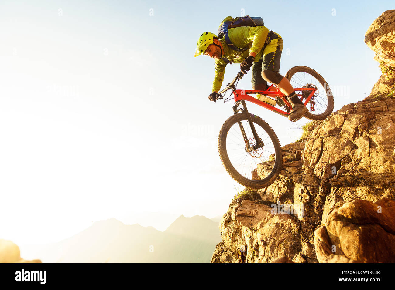Im mittleren Alter Mann fällt einem steilen Felsen clif auf seinem Mountainbike, Kitzbüheler Alpen, Tirol, Österreich Stockfoto