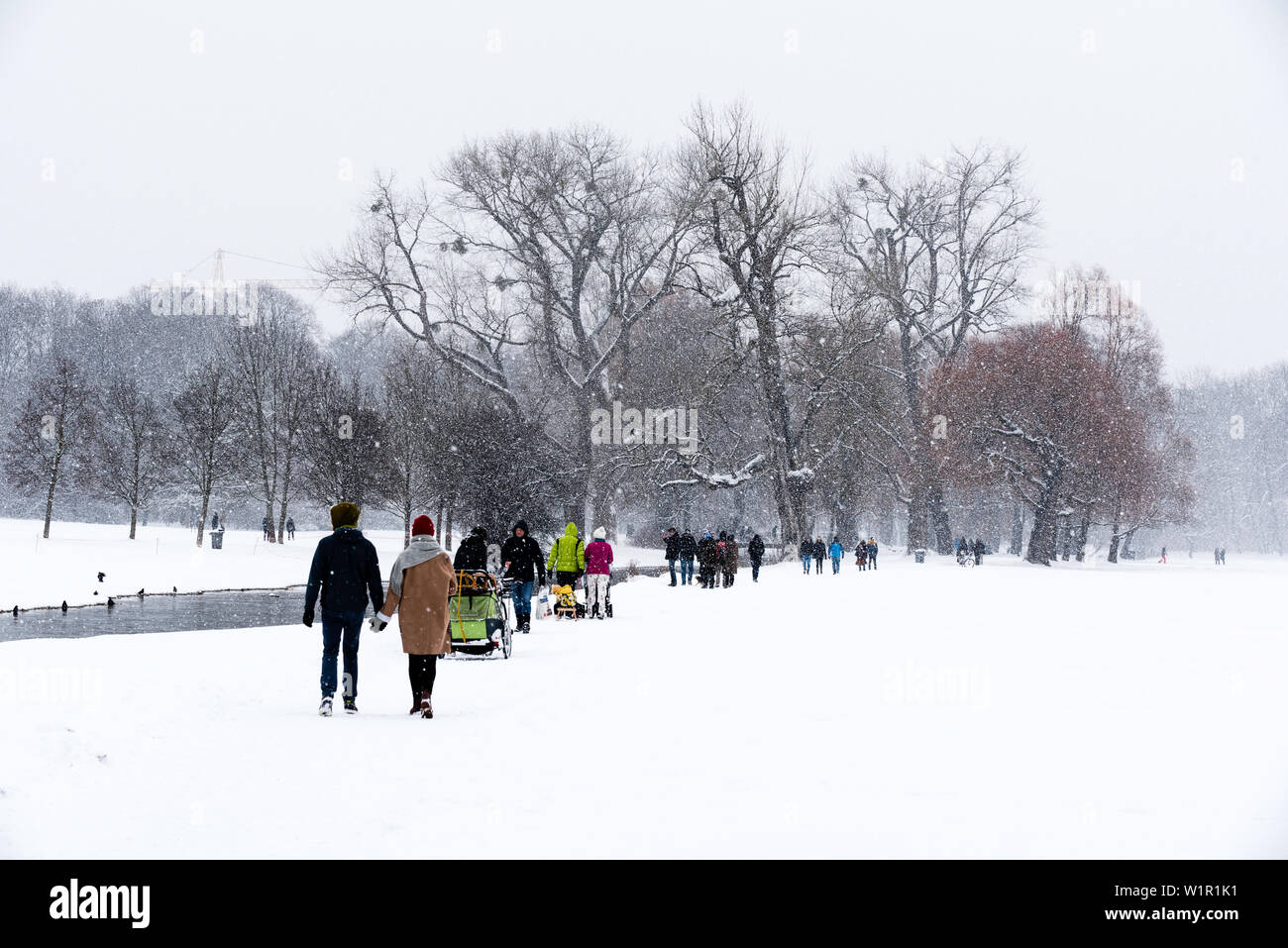 Wandern im Schnee fällt auf einen Sonntag Nachmittag, Eisbach, Englischer Garten, München, Deutschland Stockfoto