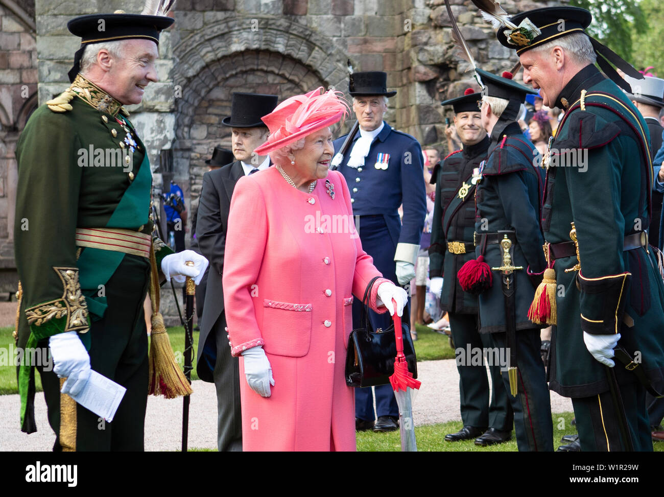 Königin Elizabeth II. grüßt die Königlichen Bogenschützen während einer Gartenparty am Palast von Holyroodhouse in Edinburgh. Stockfoto