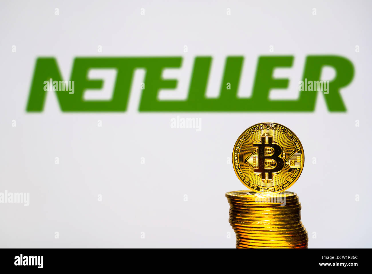 Gold Bitcoin Münzen mit der Neteller Logo auf Hintergrund. Eine neue Art von Geschäft Finanzierung Konzept Stockfoto