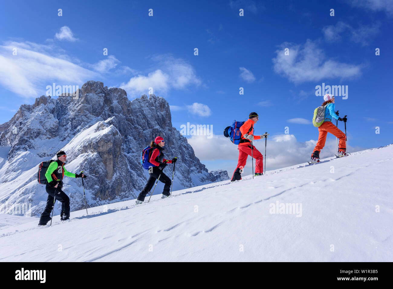 Mehrere Personen backcountry Skiing aufsteigend zu Medalges, Geisler Bereich im Hintergrund, Medalges, Naturpark Puez-Geisler, UNESCO Weltkulturerbe Stockfoto