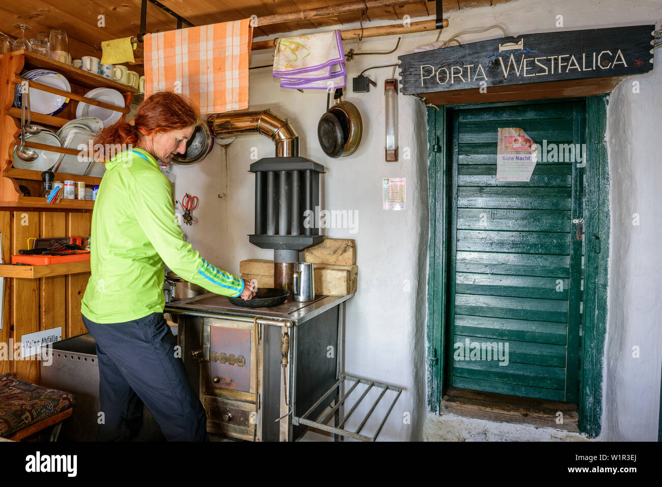 Frau kochen auf Brennholz Herd, Hütte Mindener Hütte, Tauern Höhenweg, Hohe Tauern, Salzburg, Österreich Stockfoto