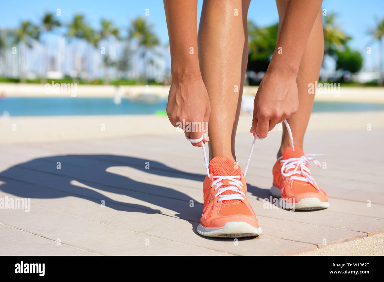 Sport Fitness, Bewegung und Lifestyle Konzept. Runner Frau schnürung Schuhe Schnürsenkel binden Trainer vor dem Joggen auf einem Lauf. Passen gesunden weiblichen Fuß und Schuh. Stockfoto