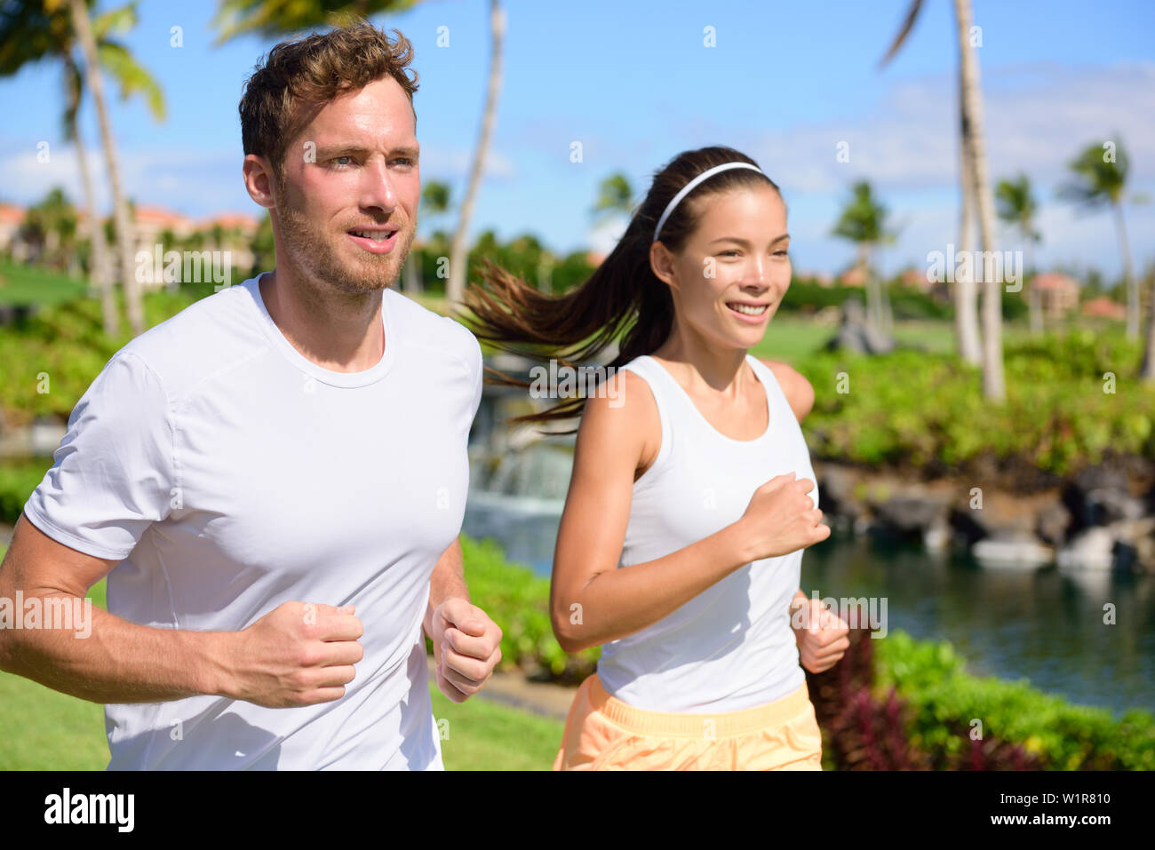 Joggen Paar Läufer zusammen im Park läuft. Aktiv Sommer Lifestyle, zwei junge Erwachsene Jogger cardio Training im City Park oder die Straße lebt gesund. Stockfoto