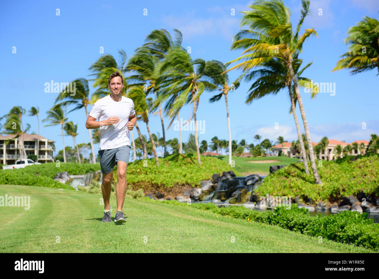 Bewegung im Freien Mann laufen auf Gras im City Park, Resort Area oder upscale Gemeinschaft. Glückliche junge männliche Läufer fit Trainieren und leben ein gesunder Lebensstil Training im Sommer im Freien Natur. Stockfoto