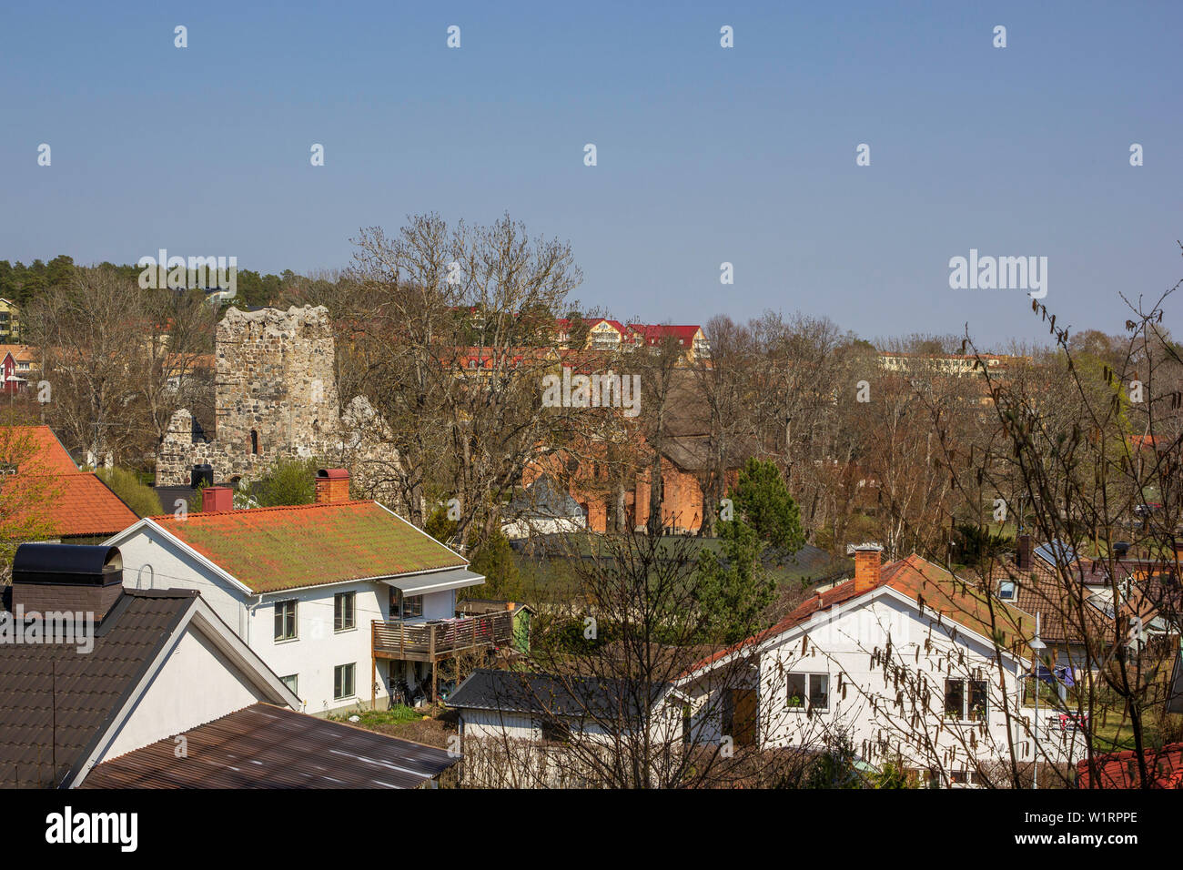 St. Olaf Kirche Ruinen aus den Wohnhäusern von Sigtuna, Schweden am Rande des Sees Malaren an einem kalten April Morgen inmitten. Stockfoto