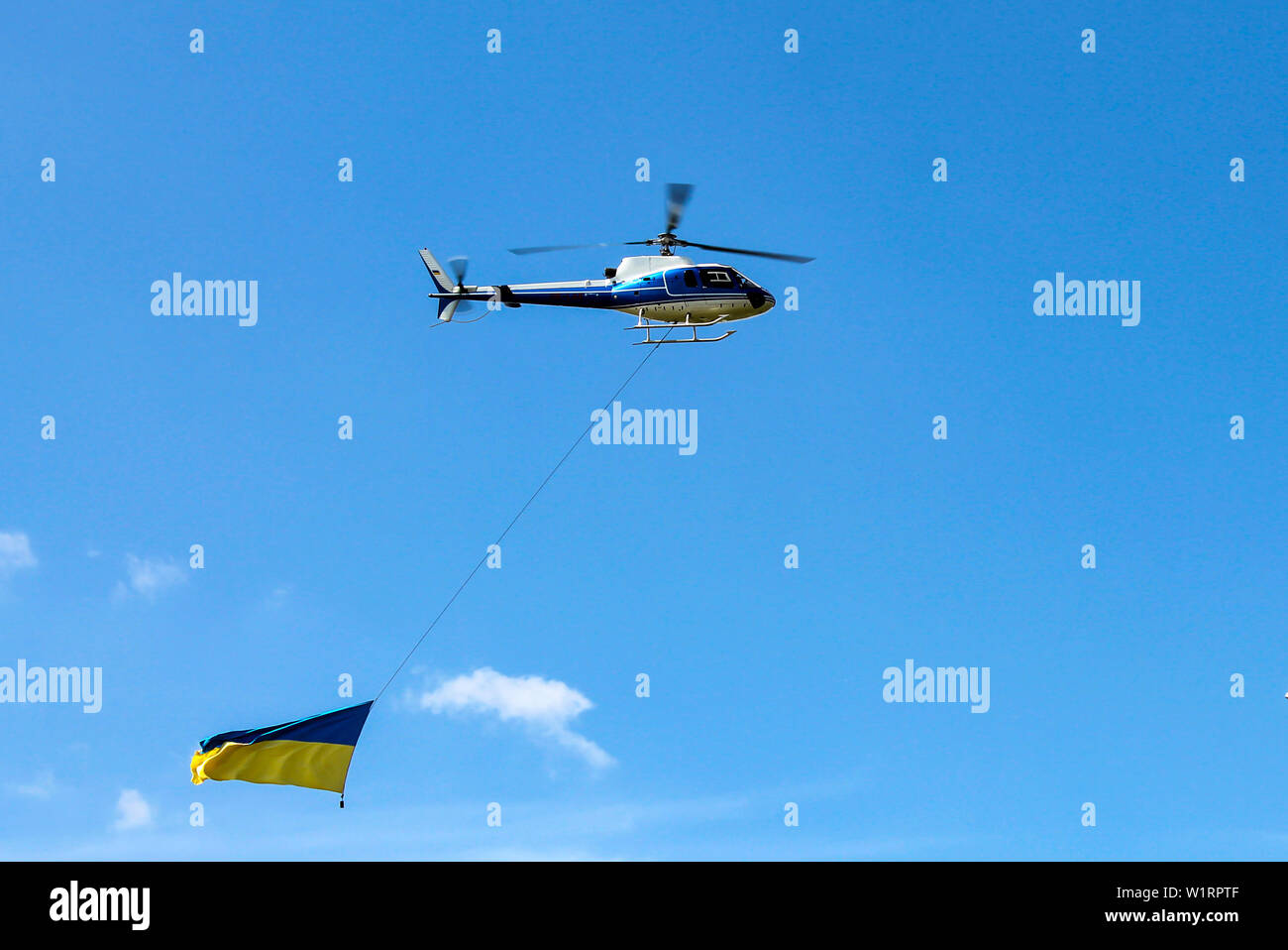 Der Helikopter fliegt mit dem nationalen Staat gelb Blaue Flagge der Ukraine. Ukrainische Flagge in den Himmel über der Stadt Dnjepr Dnjepropetrowsk. Die Ukraine Stockfoto