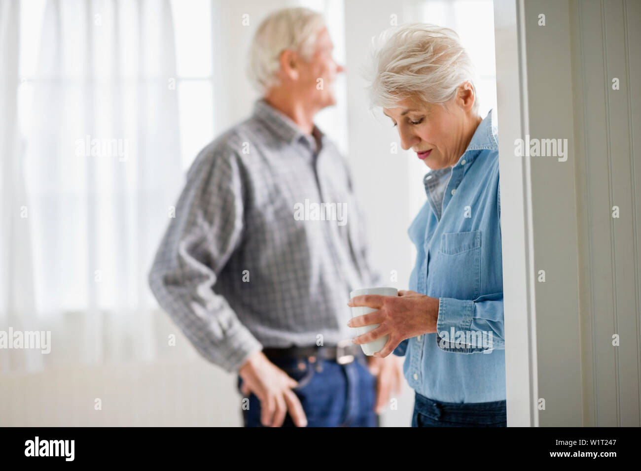 Reifen erwachsenen Paar stehend mit einem Drink in einem Raum. Stockfoto
