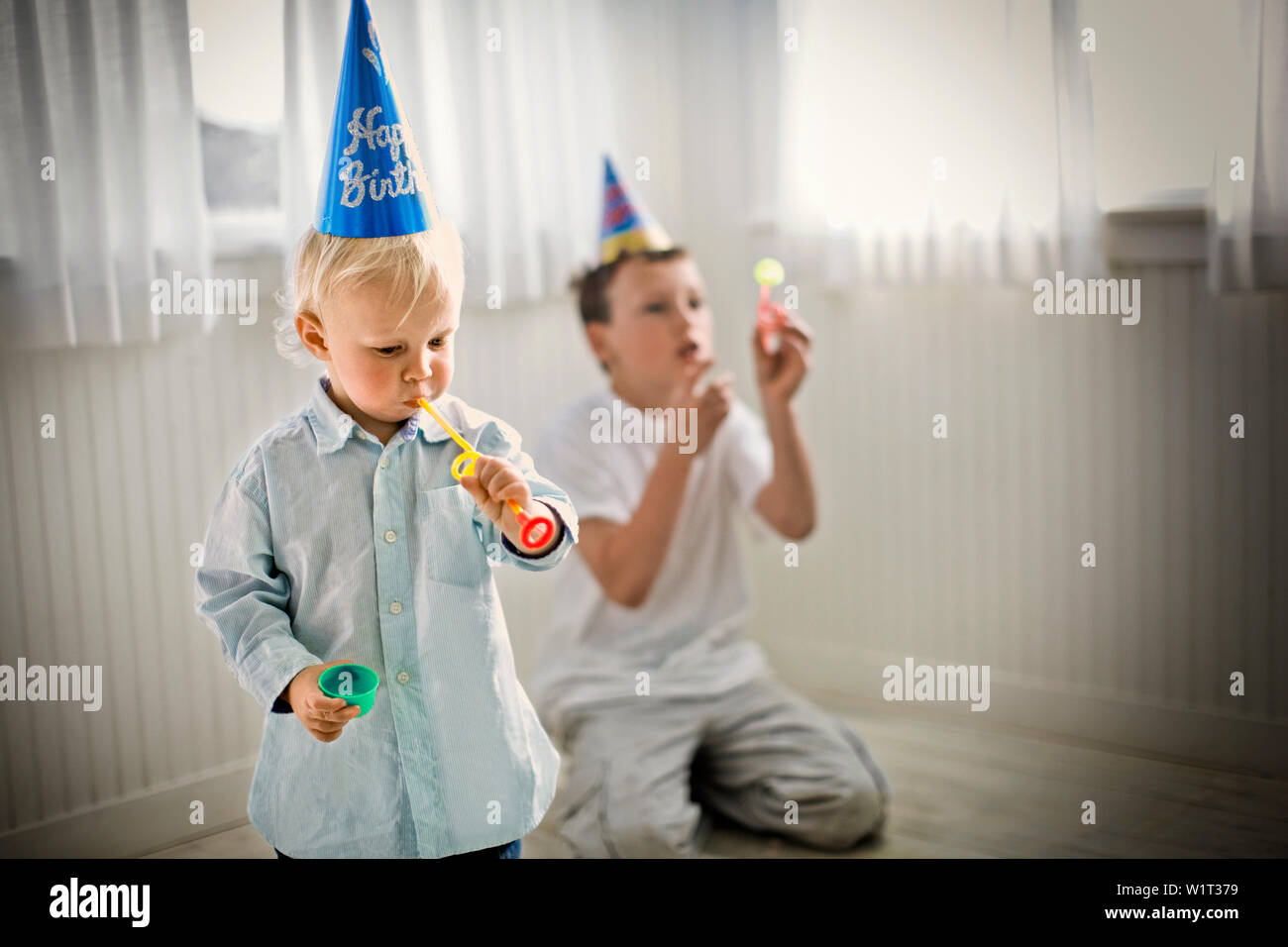 Jungen Partei tragen Hüte und Blasen Hörner Stockfoto