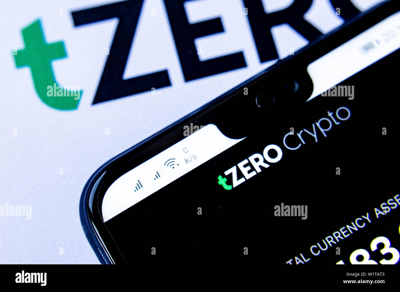 TZero Logos auf die Broschüre und das Smartphone mit dem tZERO Crypto App Screenshot. Stockfoto