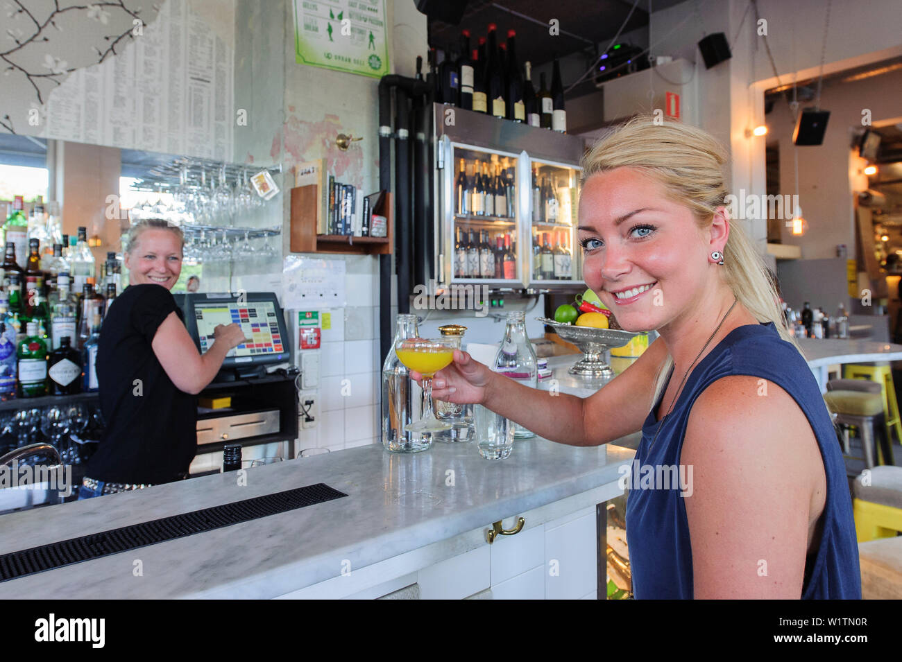 Junge Frau trinkt einen Drink im Pub Urban Deli AB SOFO, Stockholm, Schweden Stockfoto