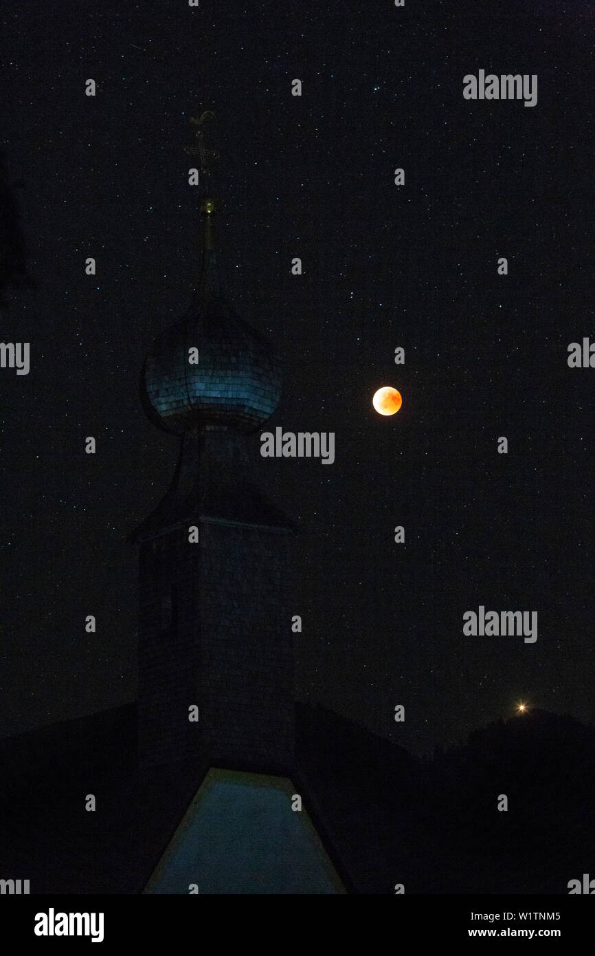 Blood Red Moon in der Mondfinsternis 2018; an der Vorderseite der Glockenturm der Kirche von almau für Übersee Stockfoto