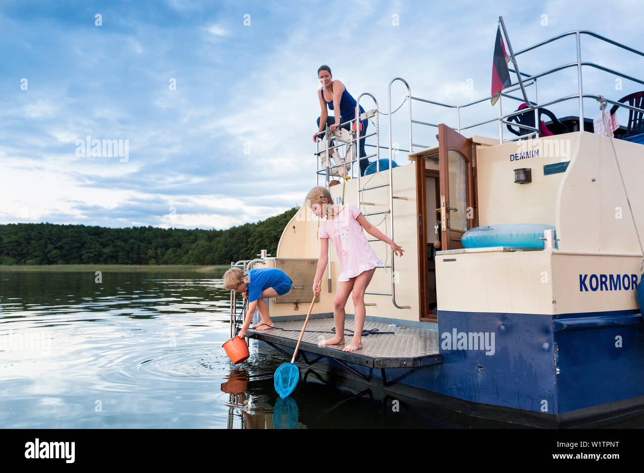 Kinder Angeln auf einem Boot, Sonnenuntergang, Hausboot tour Zotzensee, See, in der Nähe der Müritz, Kuhnle-Tours, Mecklenburgische Seenplatte, Mecklenburger Seenplatte, HERR, Stockfoto