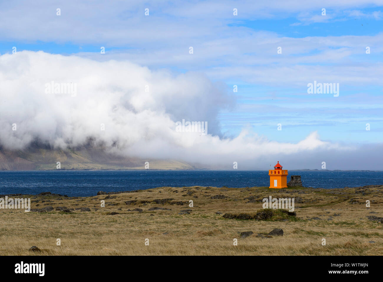 Winzige orange Leuchtturm und das Meer Nebel an der eastfjords von Island Stockfoto