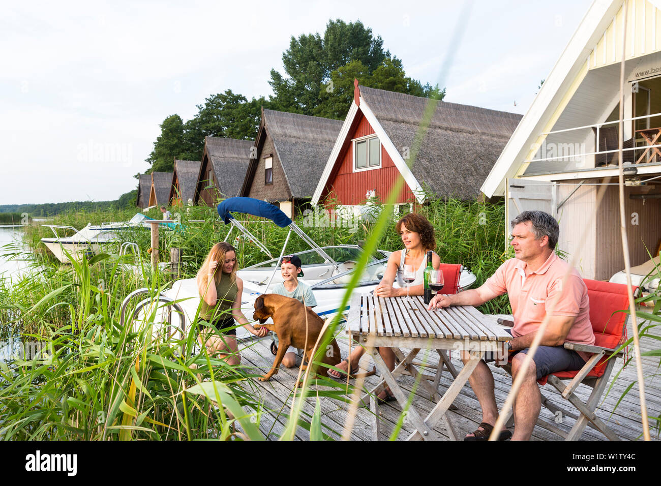 Familie genießen, am Abend auf der Terrasse mit ihrem Boot Haus