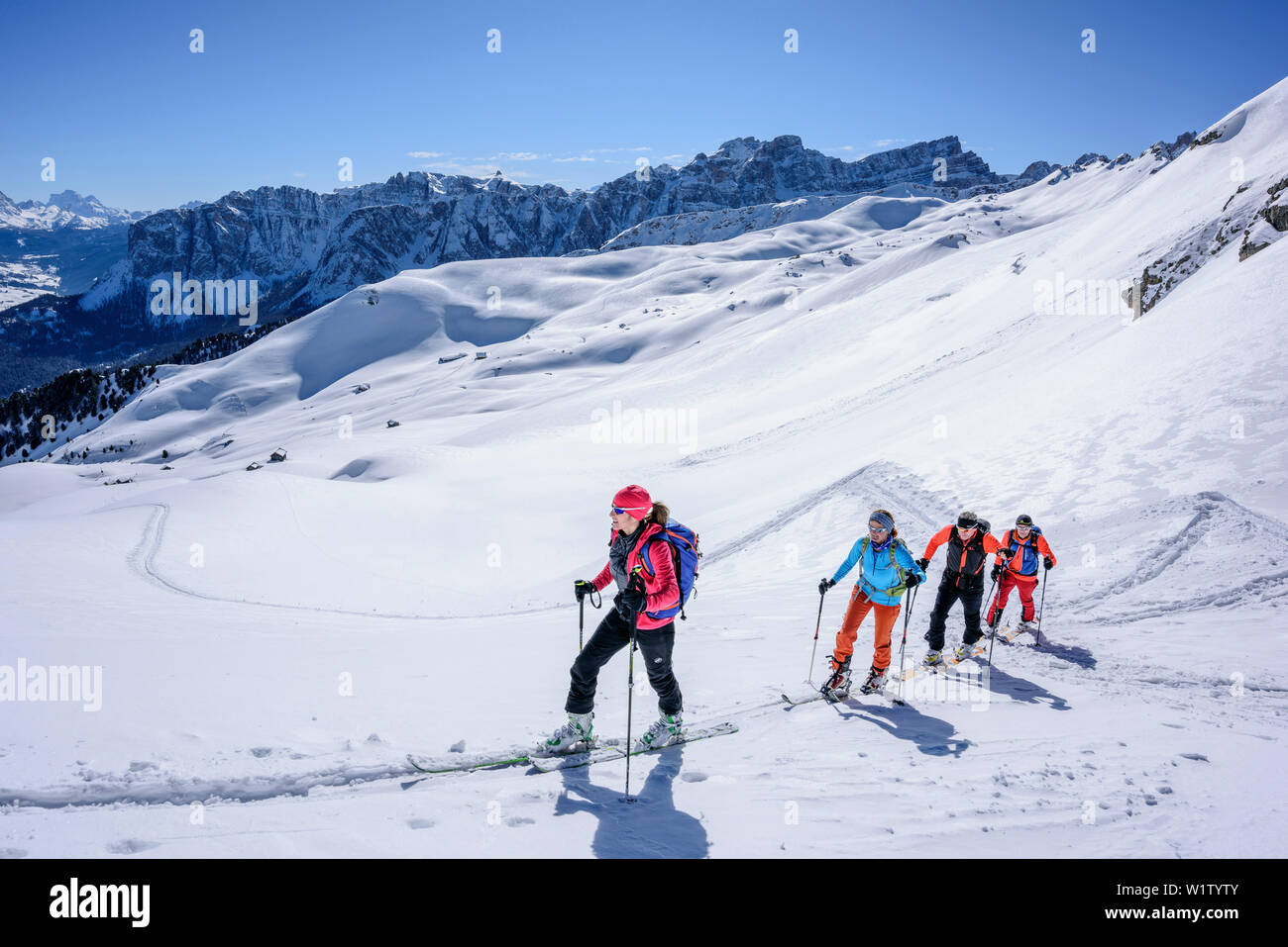 Mehrere Personen backcountry Skiing aufsteigend zu Peitlerkofel, Geisler Bereich im Hintergrund, Peitlerkofel, Naturpark Puez-Geisler, UNESCO-herit Stockfoto