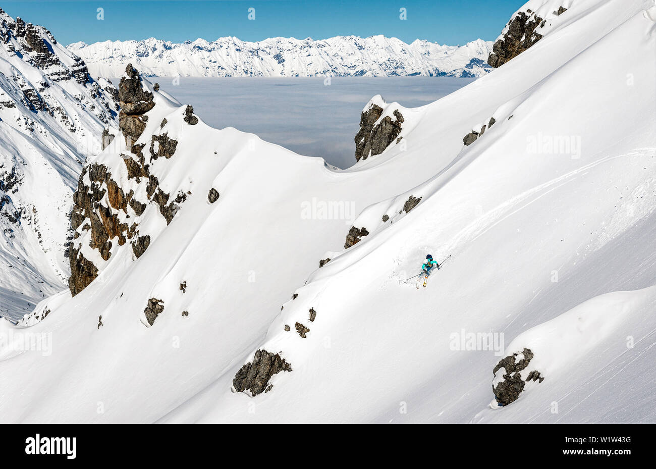 Junge Frau Himmel eine Untracked Hang mit frischem Pulver, Meer der Wolken im Hintergrund, Stubaier Alpen, Tirol, Österreich Stockfoto