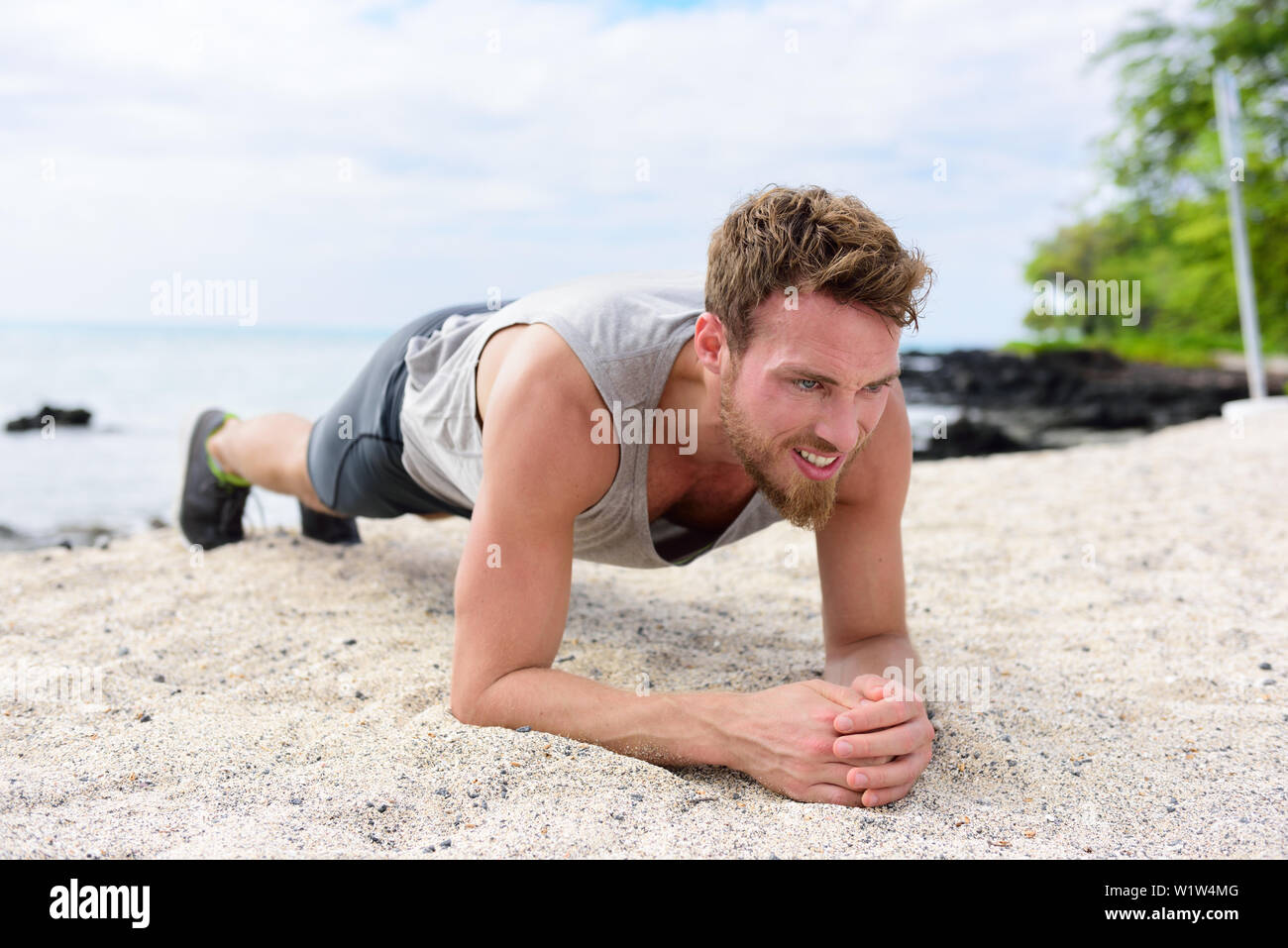 Crossfit training fitness Mann tun Plank core Übung arbeiten aus seinem Mittelteil Muskeln. Passen Athleten fitness Cross Training Beplankung Ausübung draußen im Sand am Strand. Stockfoto