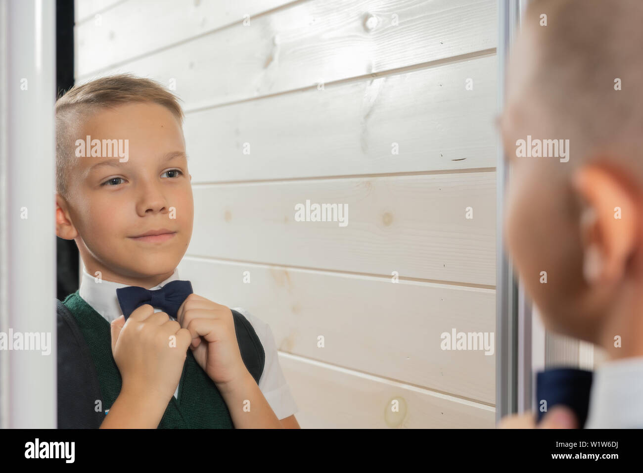 Ein 10-jähriger Junge bereitet für die Schule nach einer langen Sommerpause. Zurück zu Schule. Vor dem Spiegel Stockfoto