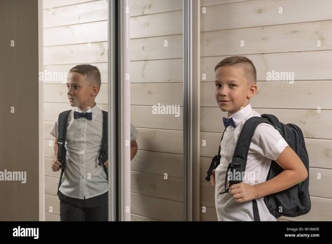 Ein 10-jähriger Junge bereitet für die Schule nach einer langen Sommerpause. Zurück zu Schule. Vor dem Spiegel Stockfoto