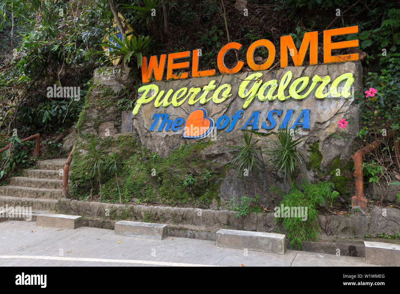 "Willkommen in Puerto Galera, im Herzen von Asien' Zeichen in Stein, Insel Mindoro, Tamaraw Wasserfälle, populäre touristische Ort der Philippinen Stockfoto