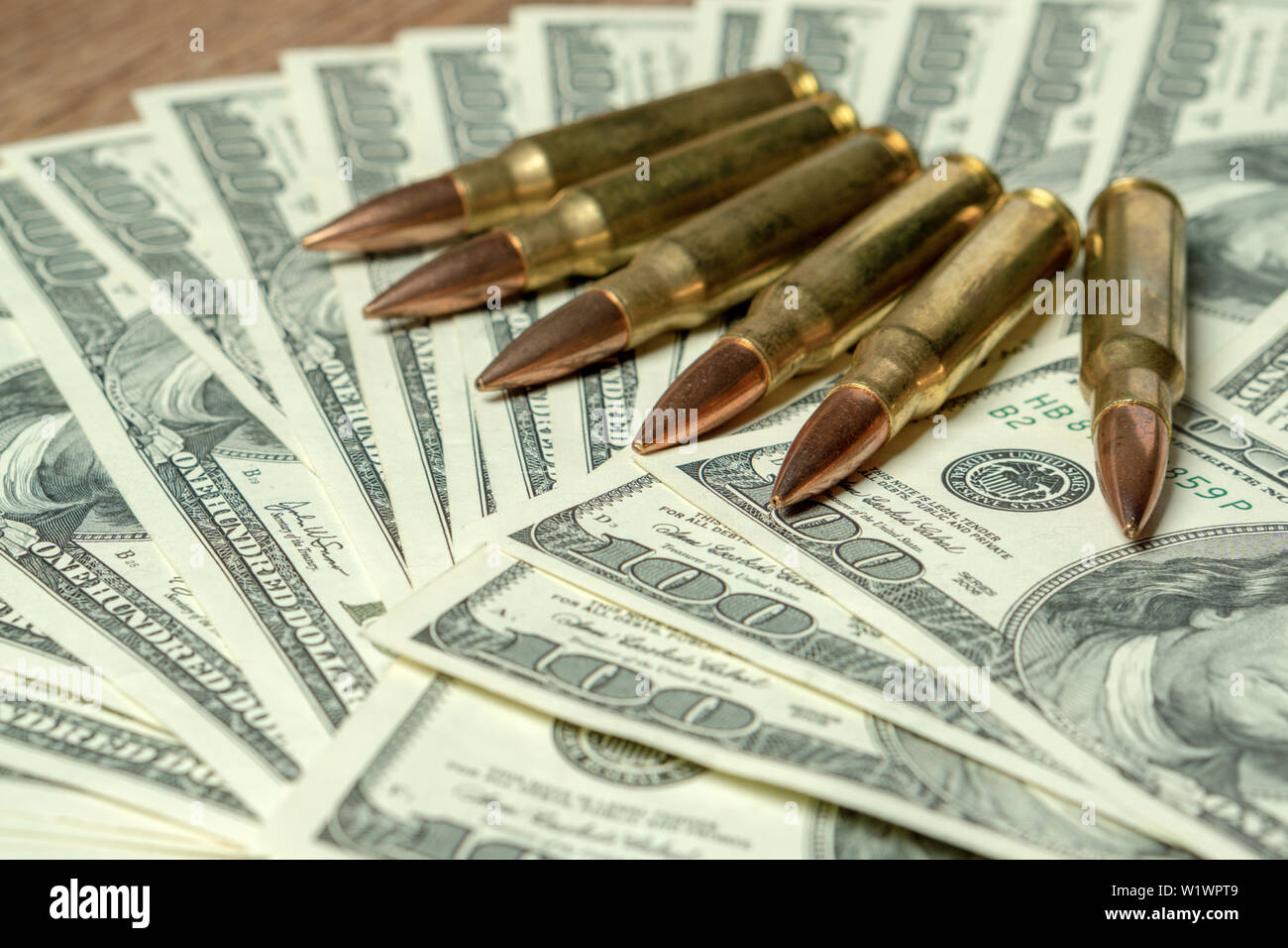 6 Gewehr Patronen auf Hundert-euro-Scheine. Konzept für Kriminalität, Mord, Mörder, Terrorismus, Krieg, globalen Waffenhandel, Waffen Verkauf Stockfoto