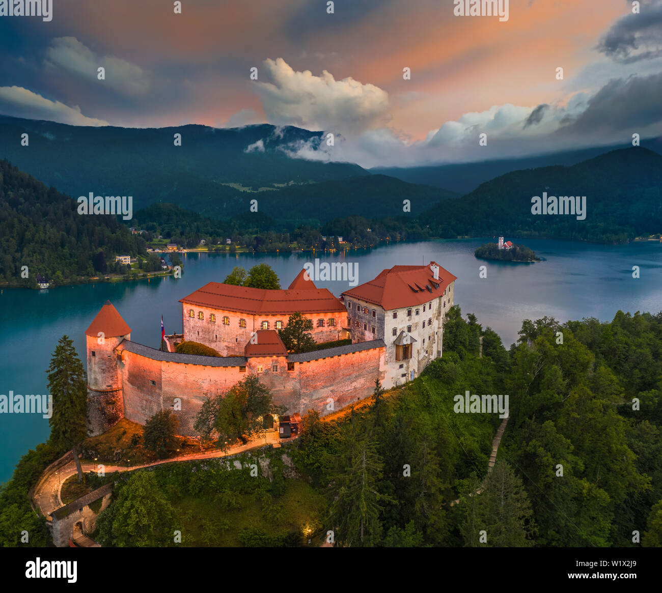 Bled, Slowenien - Luftaufnahme von wunderschön beleuchtete Burg von Bled (Blejski Grad) mit der Kirche der Himmelfahrt der Maria und Julian Alps von backgro Stockfoto