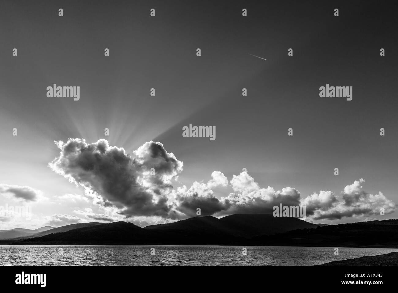 Die Sonnenstrahlen scheinen durch die Wolke über Montedoglio See (Toskana, Italien) Stockfoto