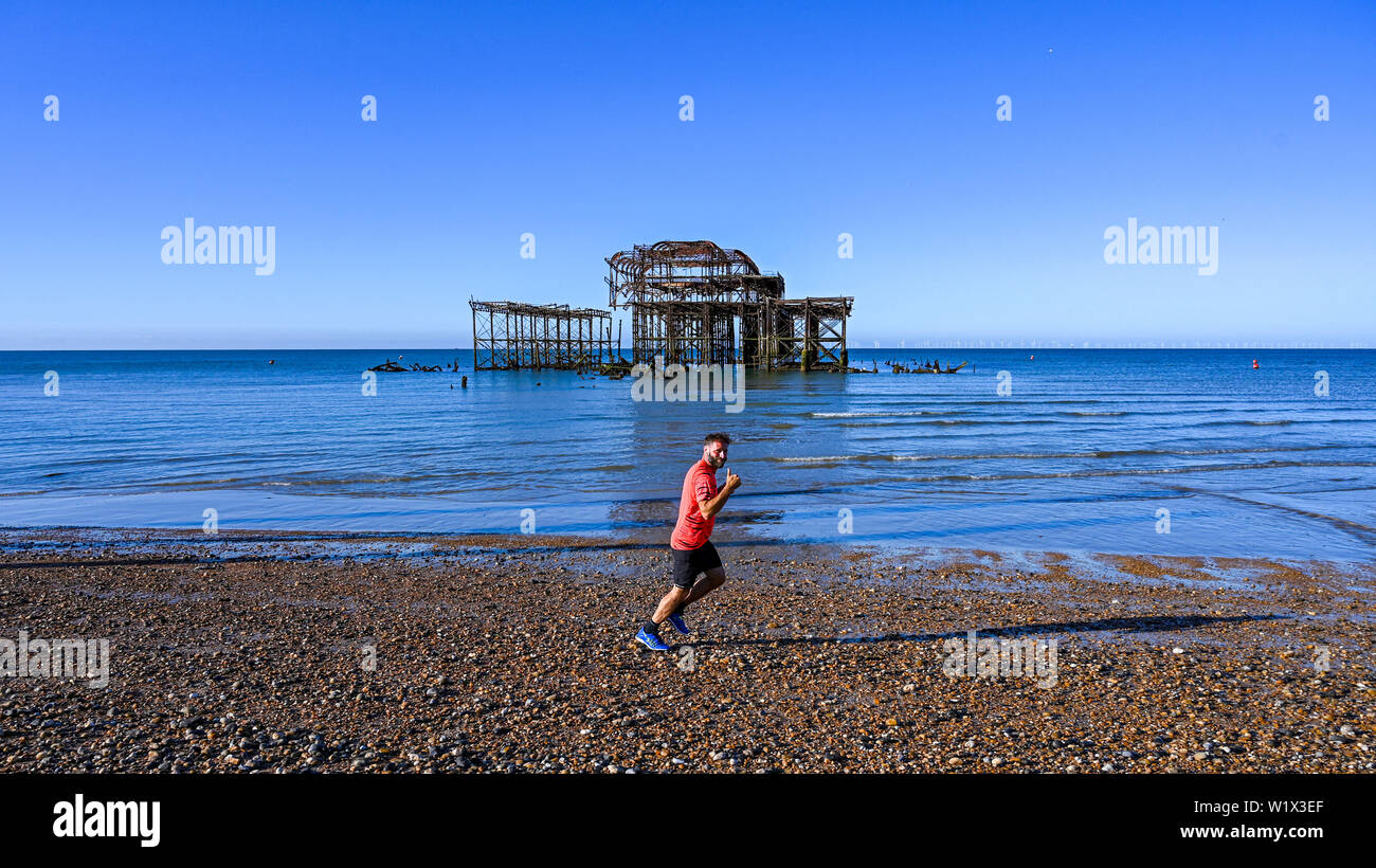 Brighton UK 4. Juli 2019 - ein Läufer genießt am frühen Morgen Sonnenschein am Brighton Beach von der West Pier mit der Wettervorhersage ein anderes heißen, sonnigen Tag an der Südküste von Großbritannien werden mit Temperaturen erwarteten 27 Grad in einigen Teilen zu erreichen. Foto: Simon Dack/Alamy leben Nachrichten Stockfoto