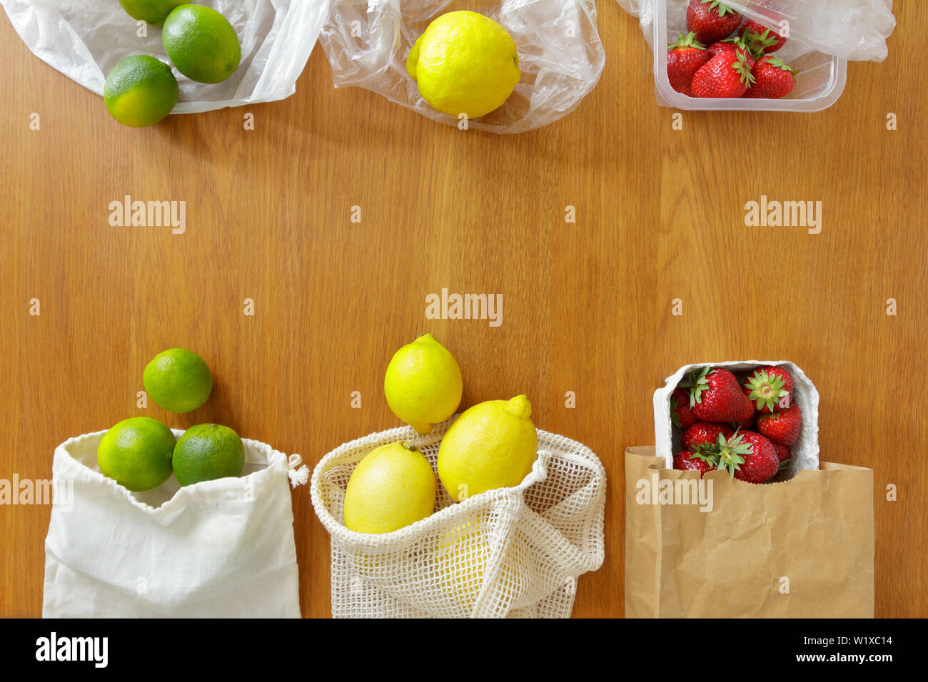 Dünne Kunststoff im Vergleich zu Baumwolle Einkaufstaschen mit frischen Früchten auf hölzernen Hintergrund, null Abfall Konzept. Stockfoto